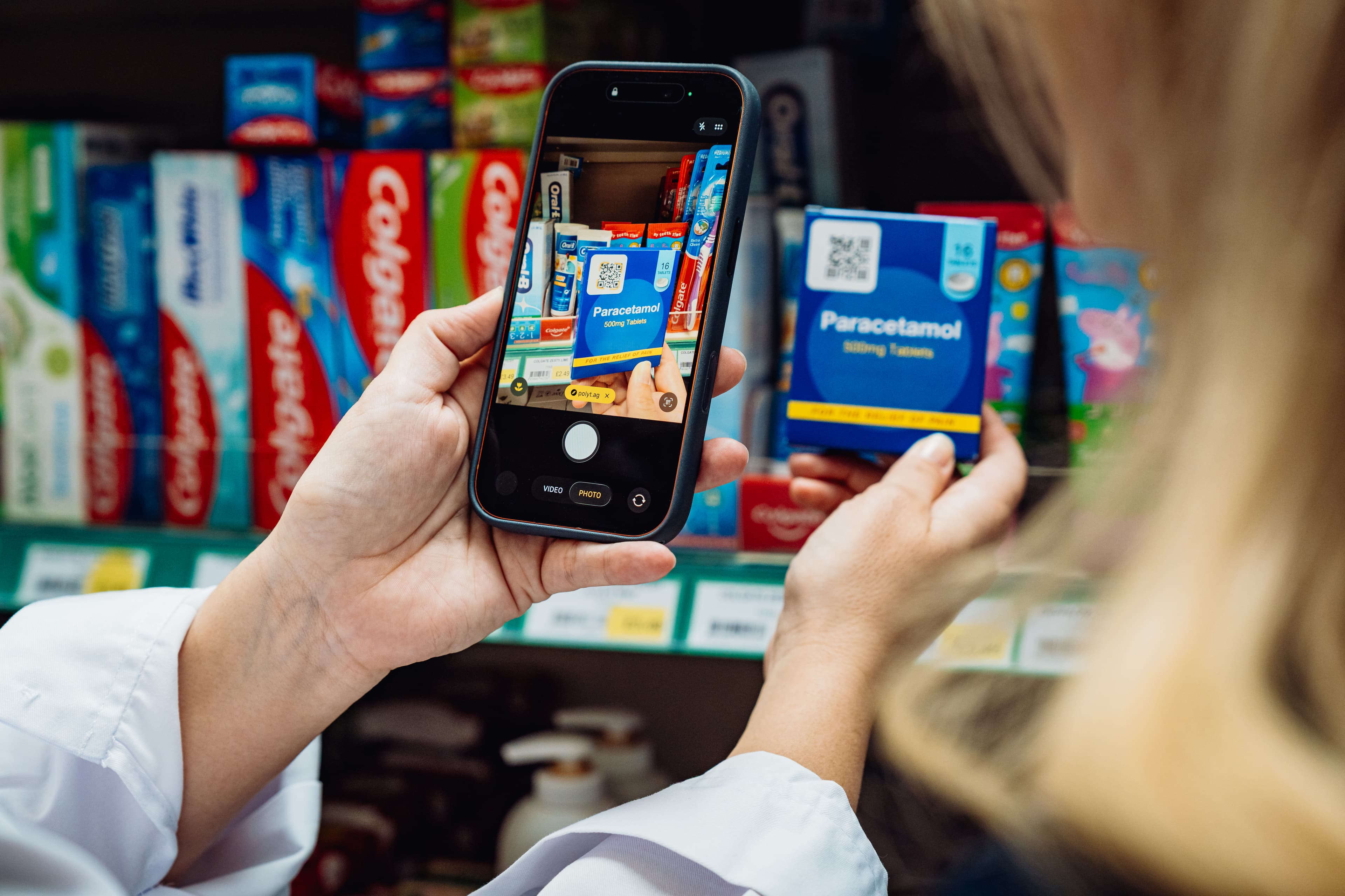 A phone camera scanning the QR code on a medicine box